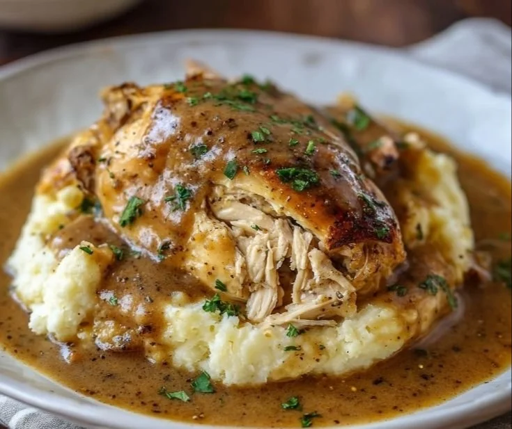 Crockpot Chicken and Gravy served with mashed potatoes.