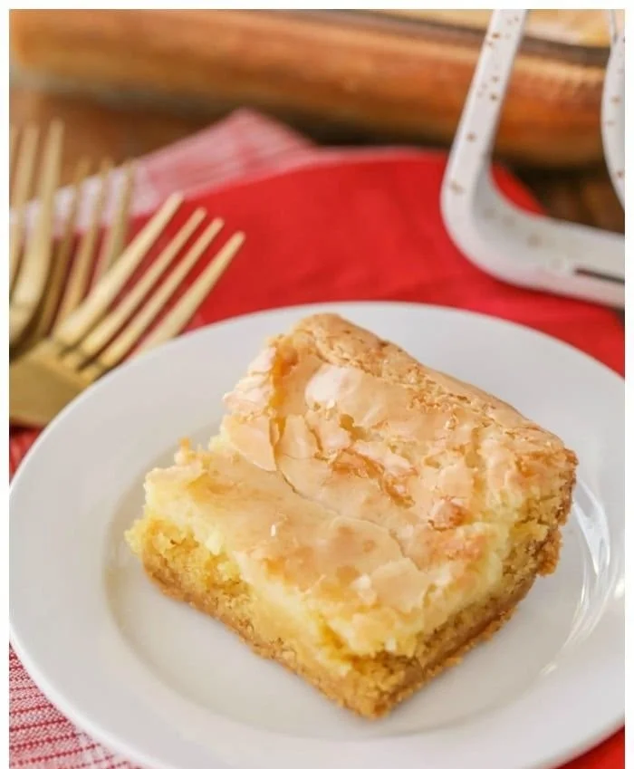 Delicious slice of Gooey Butter Cake with creamy, gooey texture and powdered sugar topping