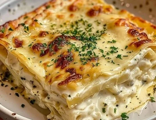 Delicious creamy white lasagna topped with herbs and melted cheese.