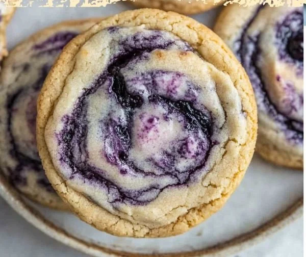 Blueberry cheesecake cookies on a plate with fresh blueberries